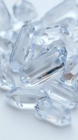 Clear crystal diamonds scattered on white surface with brilliant light reflections and prismatic effects for luxury jewelry and gemstone concepts.