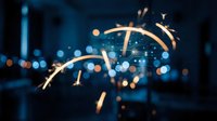 Abstract golden light trails with sparkling effects against blurred city bokeh background at night for modern digital design and creative projects.