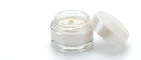 Open glass jar with cream or moisturizer inside, featuring a white lid, isolated on white background for skincare, cosmetics, and beauty product design use.