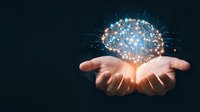 Hands holding glowing digital brain with neural network connections and light effects on dark background representing artificial intelligence and innovation.