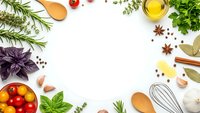 Fresh herbs and spices frame with cooking ingredients on white background. Culinary border with basil, rosemary, tomatoes, olive oil and kitchen utensils.
