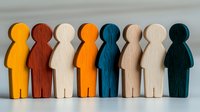 Colorful wooden figures standing in row symbolizing diversity, inclusion and teamwork concept. Minimalist composition shows unity and community spirit.