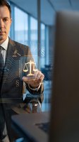 Professional businessman touching digital justice scales interface with legal technology symbols in modern office environment for law firm applications.