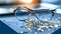Round metal frame eyeglasses with scattered golden glitter on blue surface in soft focus. Dreamy bokeh light effect creates magical atmosphere for optical or vision concepts.