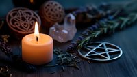 Mystical altar setup with burning candle, pentagram symbol, crystals and herbs for spiritual rituals, witchcraft practices and esoteric ceremonies.