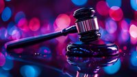 Wooden judge gavel on reflective surface with vibrant pink and blue bokeh lights background, dramatic legal concept for justice and law enforcement.