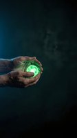 Hand holding glowing green orb against dark background, symbolizing energy, innovation, and sustainable power for technology and environmental concepts.