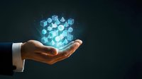 Businessman hand holding glowing digital cube made of interconnected blocks representing blockchain technology, data storage and futuristic innovation concepts.