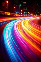 Vibrant light trails create colorful streaks on city street at night with glowing traffic lights and urban buildings in background for dynamic motion concepts.