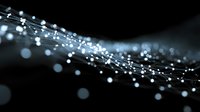Abstract flowing light particles with bokeh effects creating dynamic wave patterns on dark background for digital technology and futuristic design projects.