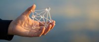 Person holding glowing network structure with connected nodes against sky background, representing digital connectivity, technology innovation, and business communication solutions.
