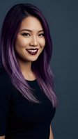 Young Asian woman with vibrant purple hair smiling confidently in black top against dark background for beauty and fashion concepts.