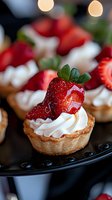 Fresh strawberry tarts with whipped cream on dark plate, gourmet dessert pastries for bakery menu, restaurant display, food photography and culinary presentations.