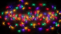 Merry and Bright text formed by glowing string lights on a dark wooden background, surrounded by colorful Christmas bulbs creating festive holiday atmosphere.