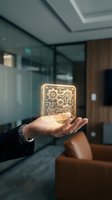 Close-up of a hand holding a glowing golden circuit board with intricate gear patterns, symbolizing technology innovation and digital transformation in a modern office environment.