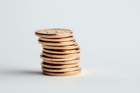 Stack of shiny copper coins on white background showing financial growth, savings and investment concept, isolated with selective focus and copy space.