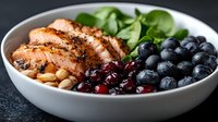 Grilled salmon fillet with fresh blueberries, cranberries, spinach leaves and nuts in white bowl on dark background, healthy protein lunch bowl.