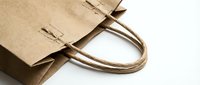 Brown kraft paper shopping bags with twisted handles for eco-friendly retail packaging and sustainable business branding solutions.