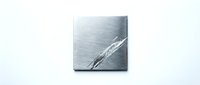 Brushed metal surface with diagonal scratch marks and metallic texture for industrial design backgrounds and modern material concepts.