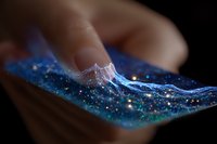 Glowing digital wave pattern on smartphone screen with blue luminescent effect and sparkles, showing futuristic technology interface in dark environment.