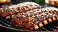 Juicy barbecue pork ribs with caramelized sauce grilling on hot bbq grates, closeup view of glazed meat with charred edges and smoky aroma.