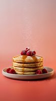 Stack of golden pancakes topped with fresh raspberries and powdered sugar on pink plate against coral gradient background with falling sugar dust.