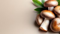 Fresh brown mushrooms with green leaves on neutral background, suitable for food, cooking, recipe, and culinary design projects.