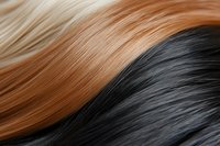 Smooth flowing waves of black and blonde hair strands create abstract pattern with soft texture and gentle curves, suitable for beauty and fashion designs.