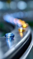 Stylish vinyl record player tonearm with blue cartridge in macro view against blurred bokeh lights background, creating atmospheric music mood.