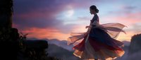 Young woman in flowing dress standing on mountain cliff at dramatic sunset with purple and orange sky colors creating romantic silhouette scene.