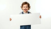 Happy toddler boy with curly hair holding blank white sign on isolated background for advertising and promotional design projects.