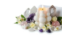 Healing crystals amethyst rose quartz with white candle and flowers for meditation wellness spa rituals on white background isolated.