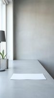 Minimalist workspace with blank white paper on concrete desk, potted plant, black lamp, and bright window light for mockup and branding projects.