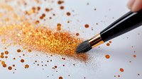 Makeup brush sweeping through scattered golden glitter powder on light background, creating dynamic motion effect for cosmetic and beauty photography.