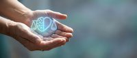 Hands holding glowing brain with neural network connections representing artificial intelligence, machine learning and cognitive technology innovation.