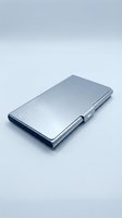 Sleek metallic wallet with brushed silver finish and snap closure, isolated on white background for business and fashion design projects.