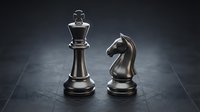 Chess king and knight pieces standing on dark board surface representing strategic thinking and leadership in business planning.