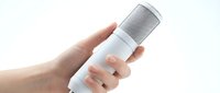 Professional white studio microphone held in hand against clean background for podcasting and audio recording applications.
