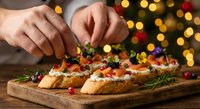 Hands garnishing festive holiday appetizers on wooden board with Christmas tree lights creating warm bokeh background for seasonal entertaining.