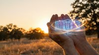 Hands holding holographic house model at sunset representing real estate technology, property investment, smart home concepts and digital architecture visualization.