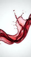 Dynamic red liquid splash with flowing waves and droplets isolated on white background for beverage and design projects.