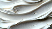 Smooth white cream texture with flowing waves and swirls, cosmetic skincare product background for beauty and wellness applications.