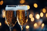 Two champagne flutes filled with sparkling wine and golden bubbles against blurred warm bokeh lights, perfect for celebration, toast, and festive event marketing.