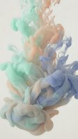 Colorful ink clouds swirling in water creating abstract fluid motion with green orange and blue hues for creative design projects and artistic backgrounds.
