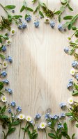 Natural spring wildflower frame with forget-me-nots and daisies on rustic wood background for botanical design projects and seasonal greeting cards.