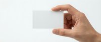 Hand holding blank white business card mockup on light background for branding and corporate identity design projects.