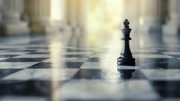 Black chess king piece standing alone on reflective checkered board with dramatic lighting and shallow depth of field creating strategic atmosphere.