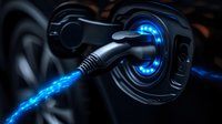 Electric vehicle charging port with glowing blue light effect and power cord plugged in, showing futuristic energy transfer technology against dark background.