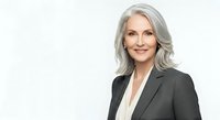 Mature woman with gray hair wearing dark blazer and white blouse, isolated on white background for corporate portraits, business headshots, professional profiles.