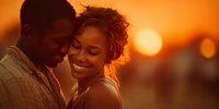 Young African American couple embracing at sunset, sharing intimate moment with warm golden light creating romantic atmosphere for wedding or engagement photography.